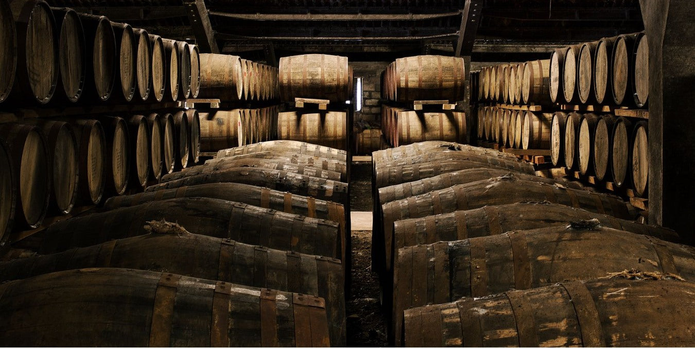 Armazém de maturação da destilaria The Dalmore, com fileiras de barricas de carvalho empilhadas